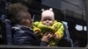 UKRAINE –A woman with a child from Siversk look though the window of a bus during evacuation near Lyman, Donetsk region, May 11, 2022