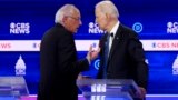 Democratic presidential hopefuls Vermont Senator Bernie Sanders (L) and Former Vice President Joe Biden (R) talk during a break in the tenth Democratic pri