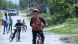 Kyrgyzstan -- boys riding a bicycle in a village close to Bishkek on May 20, 2018
