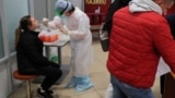 Медработница проводит тестирование на коронавирус у жительницы Беларуси в аэропорту Минска