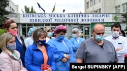  Doctors and nurses rally outside a Kyiv hospital on May 6, 2020 to protest against a salary cut linked to ongoing health-care reforms. 