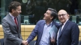Новоназначенный министр финансов Греции Эвклид Цакалотос (в центре) с министром финансов Еврогруппы Мишелем Сапином и представителем еврокредиторов 