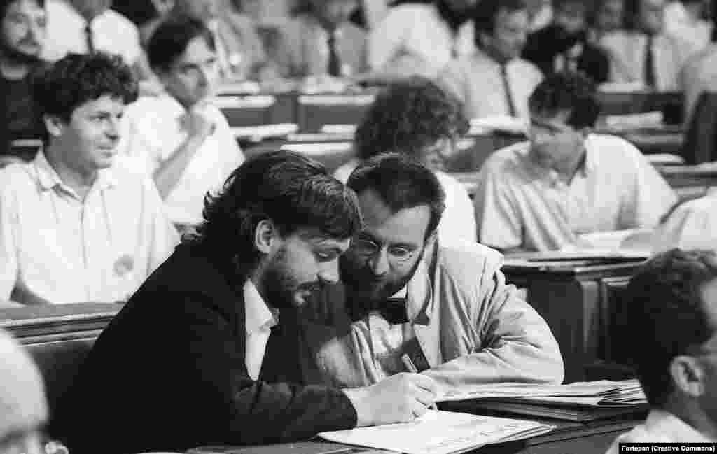 Нынешний премьер Венгрии Виктор Орбан (слева) консультируется с коллегой в венгерском парламенте, 1990 год. Молодой Орбан был известен как критик коммунистических властей Венгрии.