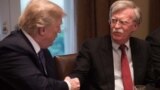 (FILES) In this file photo taken on April 9, 2018, US President Donald Trump shakes hands with National Security Advisor John Bolton during a meeting with senior military leaders at the White House in Washington, DC.