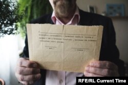 Valery Borshchev shows the paper he was given in 1995, at his home in Moscow on May 29, 2020.