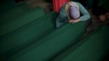 Босния-Герцеговина - мусульманка плачет на крышке гроба своего родственника, останки которого были идентифицированны наряду с другими 136 жертвами массовой резни в Сребренице в 1995 году. Мемориальный центр в Потокари близ Сребреницы, Босния и Герцеговина, 9 июля 2015