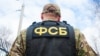 Russian FSB officer in assault gear. Translation: "FSB". Russian Federal security service - Shutterstock