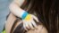 Ukraine – Hand child hugging her mother's shoulder, painted flag on the child's hand, the flag of Ukraine, the child's love for the mother