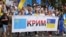 Шествие в Киеве с флагом крымских татар и украинским флагом