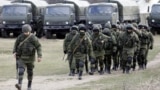 UKRAINE – Uniformed men, believed to be Russian servicemen, walk in formation near a Ukrainian military base in the village of Perevalnoye outside Simferopol, March 6, 2014