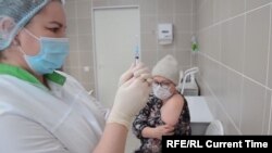 A nurse at Russia's Kemerovo Clinical Diagnostic Center prepares to vaccinate fellow nurse Olga Skripachenko with the Sputnik-V vaccine on December 9, 2020.