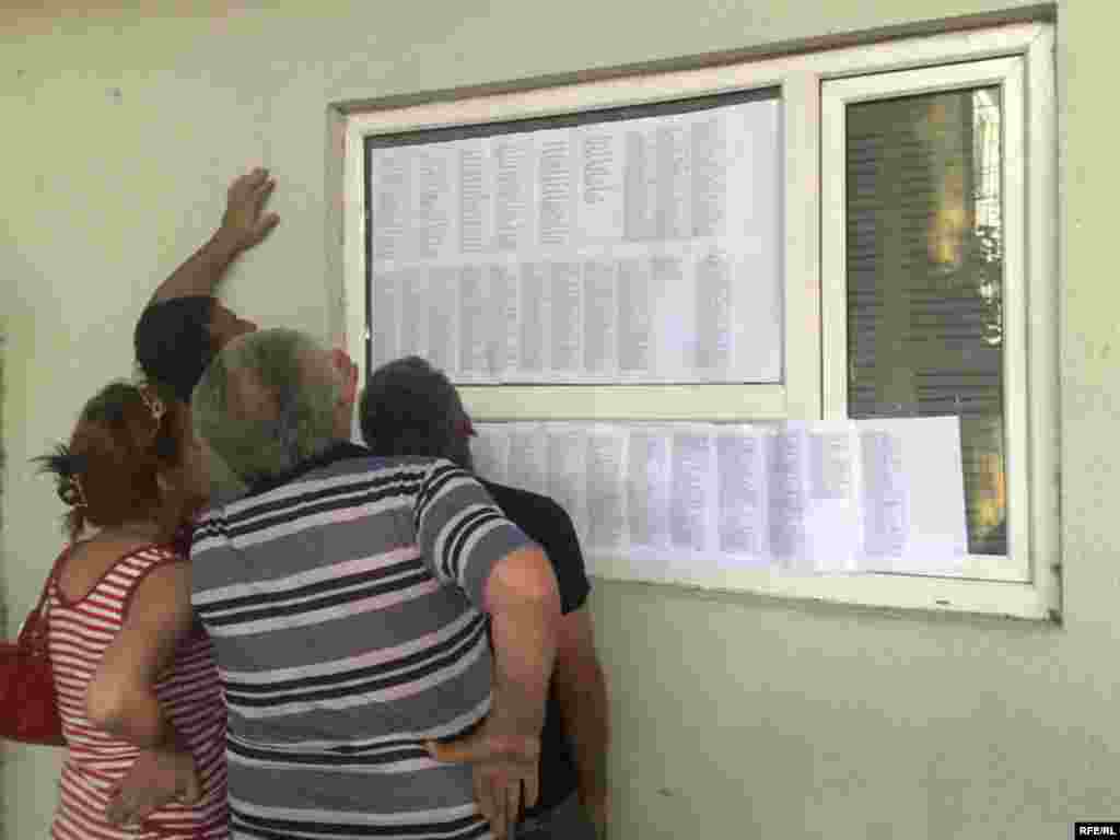 Местные жители ищут имена своих родственников в списках погибших в госпитале в Гори. 12 августа 2008