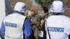 Ukraine -- Monitors of the OSCE Special Monitoring Mission to Ukraine speak to a Ukrainian serviceman in the village of Berdyanske, some 4 kms west from the village of Shirokine, April 15, 2015