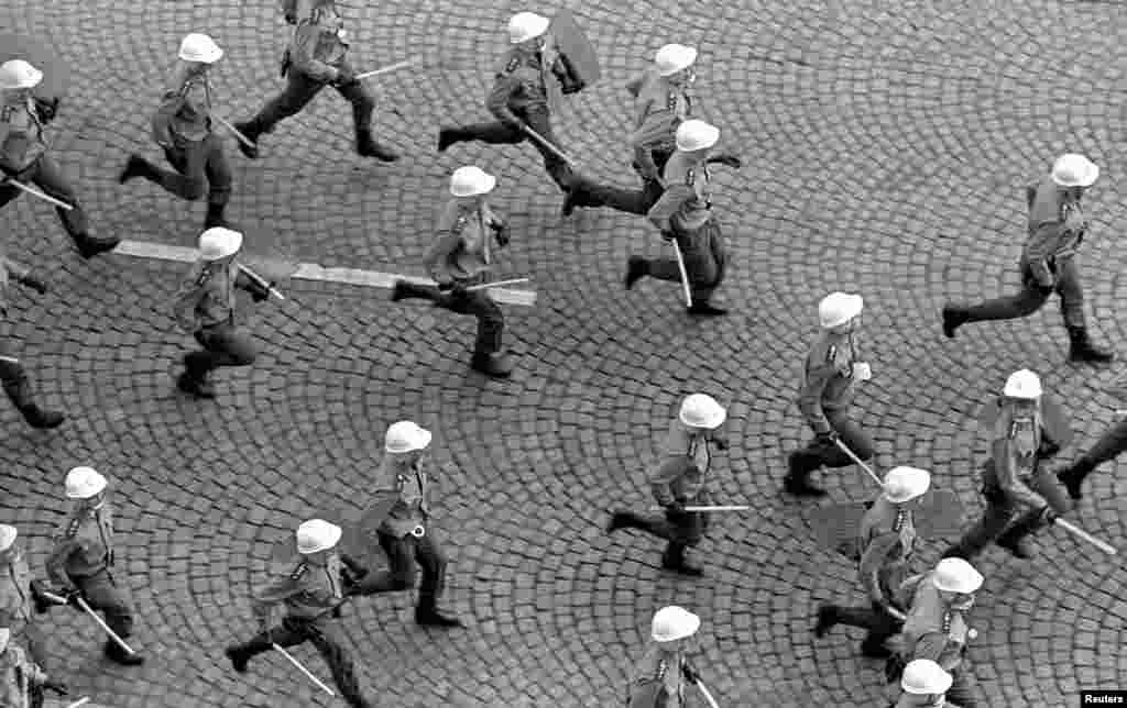 Полицейские бегут за протестующими, которые собрались в годовщину советского вторжения в Чехословакию 21 августа 1968 года