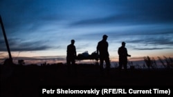 Сотрудники МЧС Украины несут тело одного из погибших при крушении Боингра MH17
