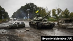 Украинский танк проезжает мимо бывшего российского блокпоста под Изюмом в Харьковской области