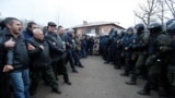 UKRAINE -- Demonstrators line up in front of Ukrainian law enforcement officers as they protest the arrival of a plane carrying evacuees from China's Hubei province hit by an outbreak of the novel coronavirus in the village of Novi Sanzhary in Poltava reg