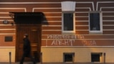 Russia -- A man walks past graffiti reading "Foreign Agents. I Love USA" on the building used by the Memorial human rights center in Moscow, 21Nov2012