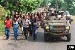Патруль французских миротворцев обгоняет колонну хуту, вооруженных мачете. Миротворцам был дан приказ не вмешиваться в происходящее. 27 июня 1994 года