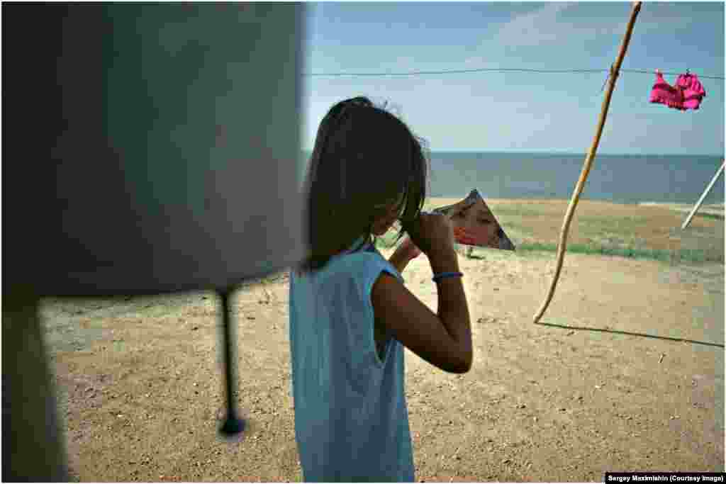 Девочка с разбитым зеркалом на берегу казахского озера Зайсан, 2005
