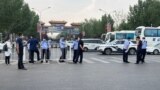 Police officers wearing face masks are seen outside an entrance of the Xinfadi wholesale market, which has been closed for business after new coronavirus infections were detected, in Beijing