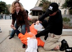 Активисты за права человека делают имитацию утопления перед зданием Капитолия в Вашингтоне в знак протеста против пыток в Гуантанамо. Ноябрь 2007 года