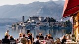 LAKE ORTA, ITALY - FEB 24: People in a restaurant in Orta on February 24, 2012. With the nearby Unesco site Sacro Monte and San Giulio island, Orta is a popular destination for small-scale tourism.