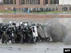 Riot police in Bishkek take cover during a protest against the Kyrgyz government on April 7, 2010.