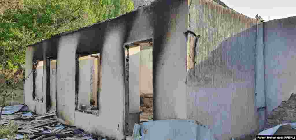 Сожженное в результате обстрелов здание в селе Сомониен в Таджикистане