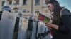 BELARUS -- An opposition supporter reads a copy of the Belarusian Constitution to riot police officers blocking a street during a rally in Minsk, September 20, 2020