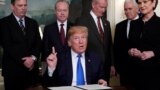 U.S. -- U.S. President Donald Trump, surrounded by business leaders and administration officials, prepares to sign a memorandum on intellectual property tariffs on high-tech goods from China, at the White House in Washington, U.S. March 22, 2018.
