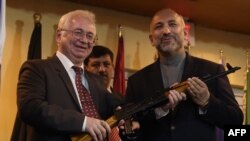 Посол РФ в Афганистане Александр Мантицкий передает партию автоматов советнику по вопросам национальной безопасности Ганифу Атмару 24 февраля 2016 года 