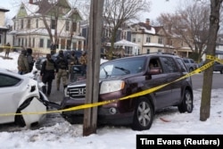 Федеральные агенты рядом с автомобилем Николь Гудман, которая была убита тремя выстрелами в голову 7 января. Фото: Reuters