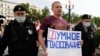 Moscow police detain an opposition activist with a poster reading "Smart Voting" during an anti- COVID-19 vaccination protest in the Russian capital on August 14, 2021.