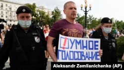 Полиция задерживает в Москве мужчину с плакатом "Умное голосование", август 2021 года. Фото: AP