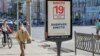 A man walks past a campaign poster put up ahead of the elections to the Russian State Duma scheduled for September 17-19
