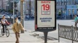 A man walks past a campaign poster put up ahead of the elections to the Russian State Duma scheduled for September 17-19