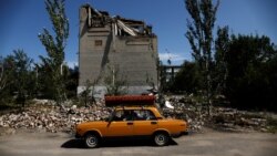 Пожилой украинский беженец уезжает из своего разрушенного дома в Торецке Донецкой области 22 августа 2022 года