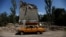 62-year-old Ukrainian Arkadii drives a car after leaving his destroyed house, as Russia's attack on Ukraine continues, in Toretsk