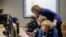Estonia -- Teacher Kristi Rahn (C) helps to first grade students during a computer lesson in school in Tallinn, September 25, 2012