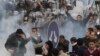 FILE - In this Friday, Jan. 28, 2011 file photo, anti-government activists clash with riot police in Cairo, Egypt, to challenge President Hosni Mubarak's 30-year rule