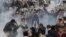 FILE - In this Friday, Jan. 28, 2011 file photo, anti-government activists clash with riot police in Cairo, Egypt, to challenge President Hosni Mubarak's 30-year rule