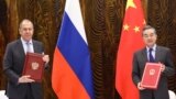 CHINA -- Russian Foreign Minister Sergei Lavrov (L) and Chinese Foreign Minister Wang Yi pose during a signing cerenony following their talks in Guilin, March 23, 2021