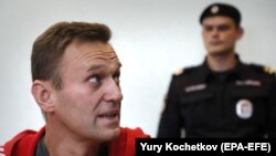 Russian opposition figure Aleksei Navalny (left) attends a court hearing in Moscow on August 22, 2019.