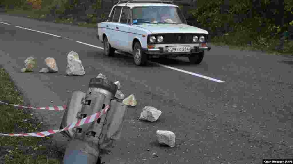 A rocket fragment on a road near the Karabakhi town of Shusha (Shushi in Armenian), just over a week before Azerbaijani forces retook control of the town from ethnic Armenian separatists on November 8, 2020. A subsequent truce between Armenia, Azerbaijan, and Russia formally turned Shusha over to Azerbaijan and will introduce nearly 2,000 Russian peacekeepers into Nagorno- Karabakh. Three days after the agreement went into effect on November 10, 2020, a Russian peacekeeper and Azerbaijani service member stood together on a road in Shusha's outskirts.&nbsp;