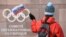 SWITZERLAND -- A supporter waves a Russian flag in front of the logo of the International Olympic Committee (IOC) at their headquarters in Pully near Lausanne, December 5, 2017