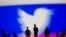RUSSIA -- Small toy figures are seen in front of Twitter logo and Russian flag colors - generic
