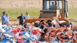 Russia -- A worker uses a bulldozer to crush crates of peaches outside the city of Novozybkov, about 600 km from Moscow, August 7, 2015