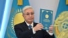 Президент Касым-Жомарт Токаев держит Конституцию Казахстана