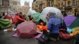 Climate change activists from the Extinction Rebellion sit at a make-shift camp outside Westminster Abbey in central London, on October 7, 2019 
